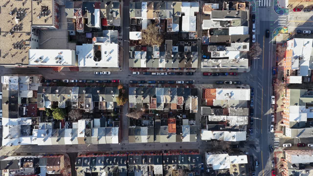 Luftoptagelse af rækkehuse i Baltimore filmet i dagslys, der viser tætte bykvarterer, boligtage, parkerede biler og et klassisk bymønster fra den amerikanske østkyst. Fredeligt distrikt, Maryland