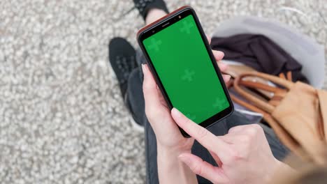 smartphone green screen mockup, top view of woman using phone.