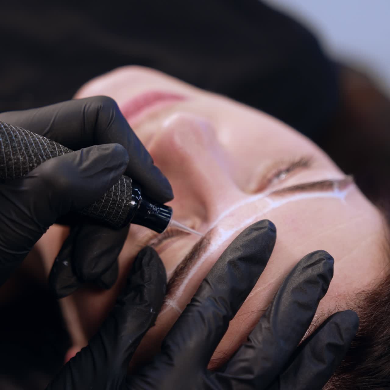 Permanent make up instrument held in the gloved hand of a brow master. Cosmetology and beauty concept
