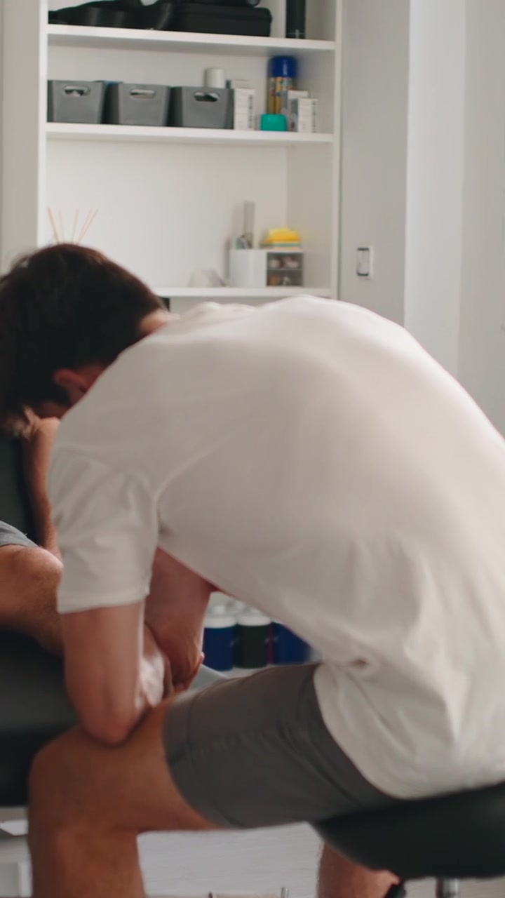 Physical Therapist Performing Leg Massage on Patient in Clinic