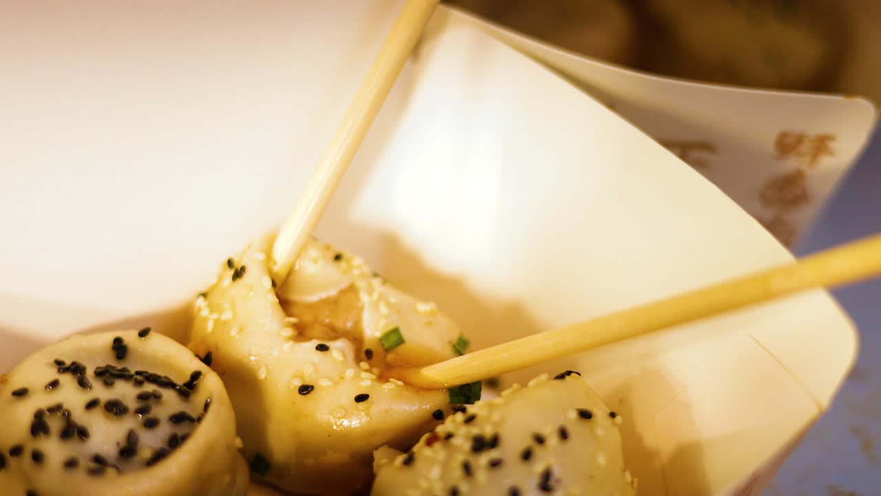 Chopsticks picking up delicious pan-fried buns