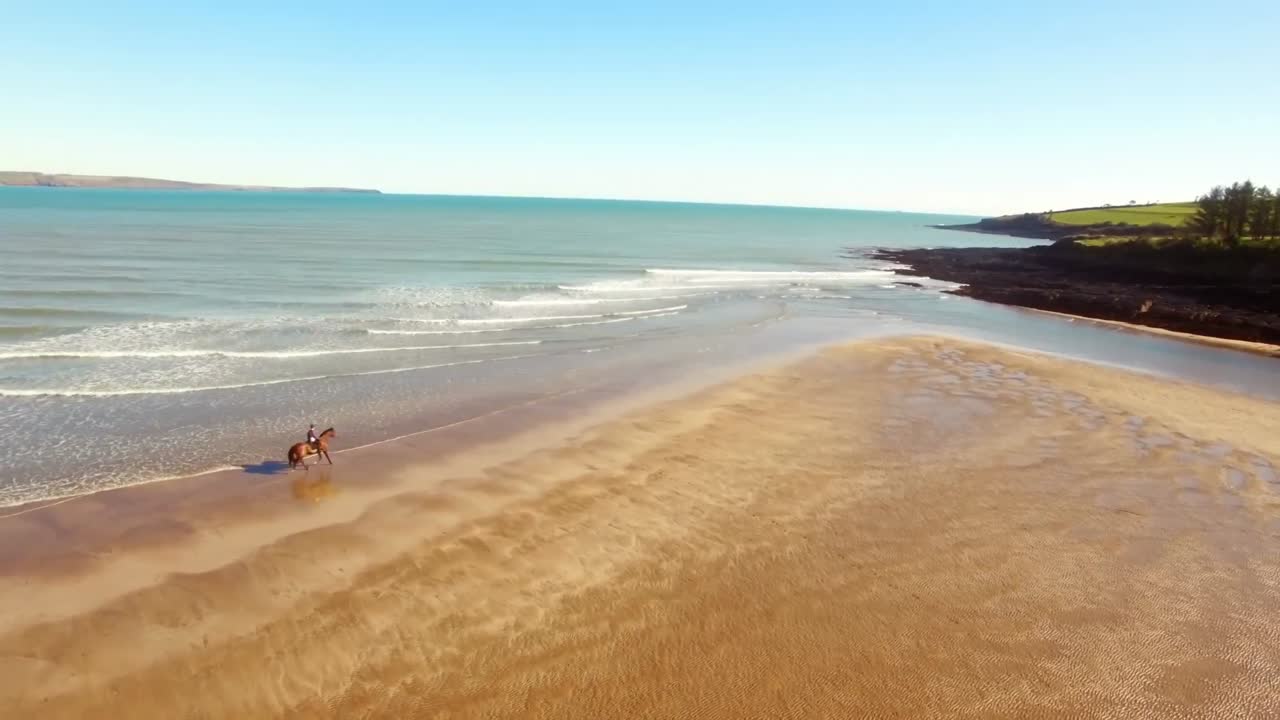 Donna a cavallo sulla riva del mare