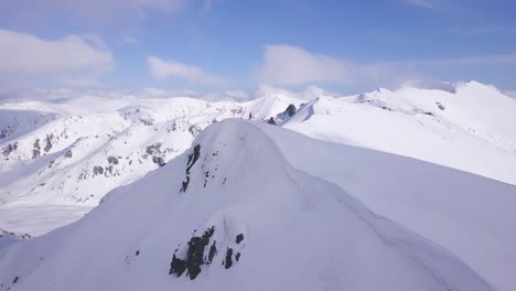 person standing on snow covered mountain peak with panoramic view of winter wonderland landscape