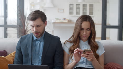 Husband-and-wife-working-together-in-home-office.-Couple-using-laptop.