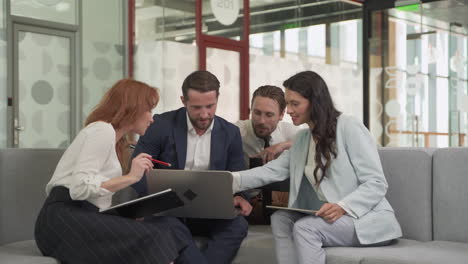 arbeitsteam bestehend aus zwei frauen und zwei männern um einen laptop herum gemeinsame probleme 1