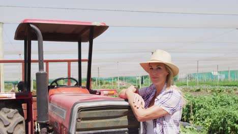 Video-of-happy-caucasian-woman-standing-in-front-of-tractor