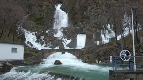 Cascadas-Que-Brotan-En-La-Ladera-Cerca-De-La-Presa-Después-De-La-Lluvia,-Inclínate-Hacia-Abajo