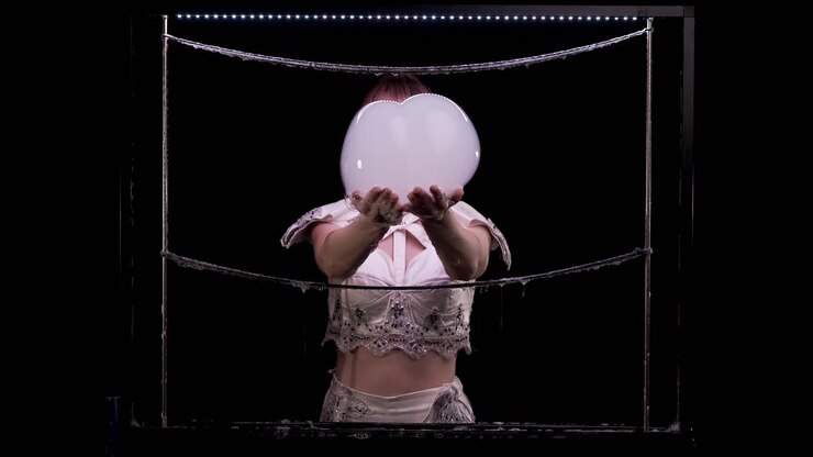 Ragazza fa trucchi con le bolle di sapone. Prende due grandi bolle con le mani, poi le scrolla via.