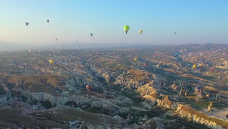 muchos globos aerostáticos flotando sobre el paisaje de capadocia, antena panorámica delantera