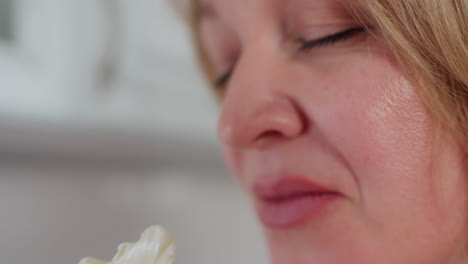 vista de cerca de la mano de una persona que sostiene la mantequilla cremosa en el dedo, acercándola a la nariz mientras percibe el aroma con expresión satisfecha en la cocina moderna