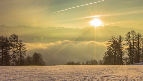 sunrise behind silhouette of mountain with flowing clouds bellow, fusion time lapse