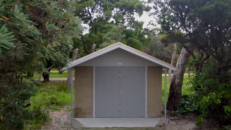 pull out shot of a boat shed hut in amongst trees