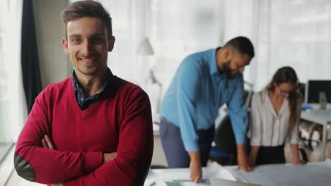 Handsome-smiling-young-man-with-crossed-arms-looking-at-camera.