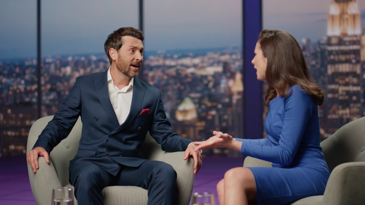 experto en el programa en vivo hablando con la mujer sonriente anfitriona sentada en el estudio de medios juntos.
