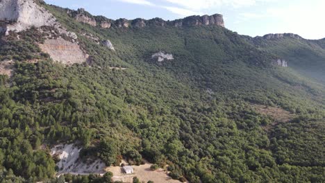 Fresh-lush-green-mountainous-forest-land-with-brown-orange-rocky-outcrops