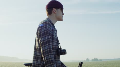 young man with bike in a wheat field