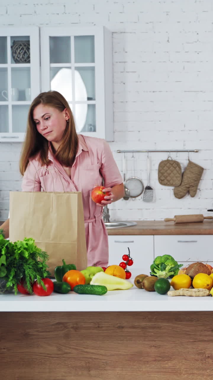 Woman cooking in kitchen. Portrait of smiling young housewife in modern kitchen Vertical video