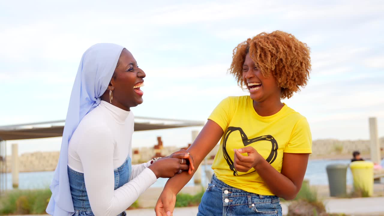 Two Friends Laughing Together Outdoors
