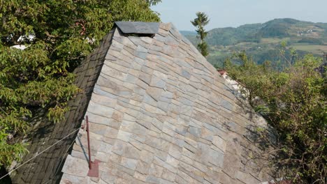 Stone-Plates-Roof-Above-Traditional-Rural-House---aerial-drone-shot