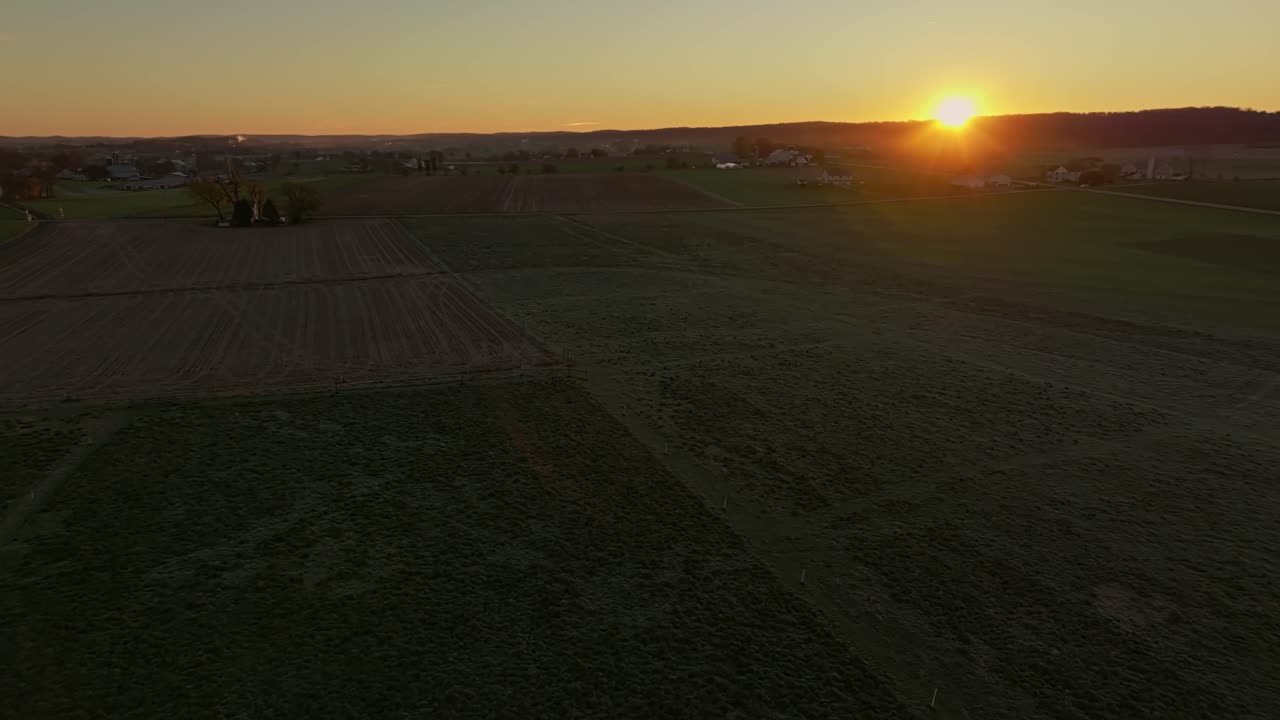 vista de drones moviéndose de izquierda a derecha de un amanecer matutino mirando las tierras de cultivo del país en una mañana de otoño