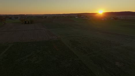 drone view moving left to right of an morning sunrise looking over country farmlands on a fall morning