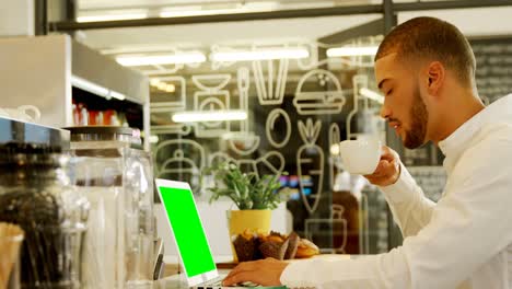 Handsome-man-using-laptop-while-having-coffee-4k