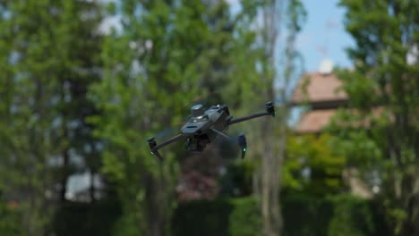 stationary mavic quadcopter drone suspended in air tilts nose and flies away