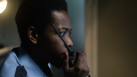man in uniform using walkie talkie indoors