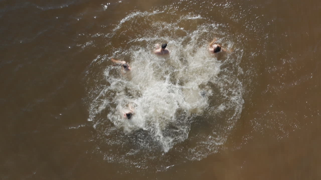 vista aérea amigos saltando del muelle en el lago divirtiéndose salpicándose en el agua disfrutando de la libertad en las vacaciones de verano vista aérea de drones desde arriba