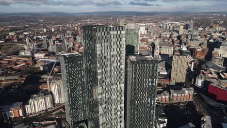 vuelo aéreo de drones de 4k 60fps que pasa por las torres elizabeth sur con el centro de la ciudad de manchester y la torre beetham en el fondo y los tranvías debajo