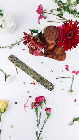hermoso arreglo floral con quemador de incienso y escultura de madera