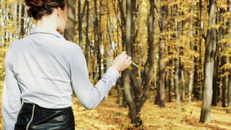 fashion woman walking in autumn park. outdoor fashion video of young beautiful lady surrounded autumn leaves