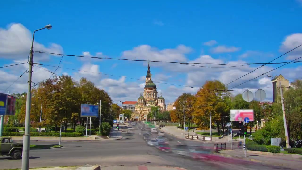 Timelapse hyperlapse da Catedral da Anunciação com tráfego na estrada. É uma das igrejas ortodoxas mais altas, com seu portão decorado com cúpula de cebola dourada e ícones, Carcóvia, Ucrânia.