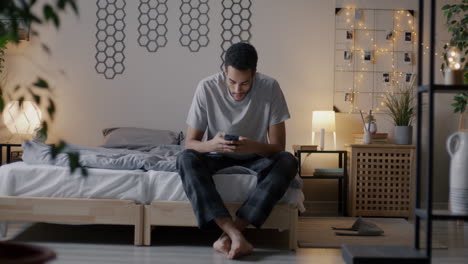 hombre usando teléfono inteligente en la cama