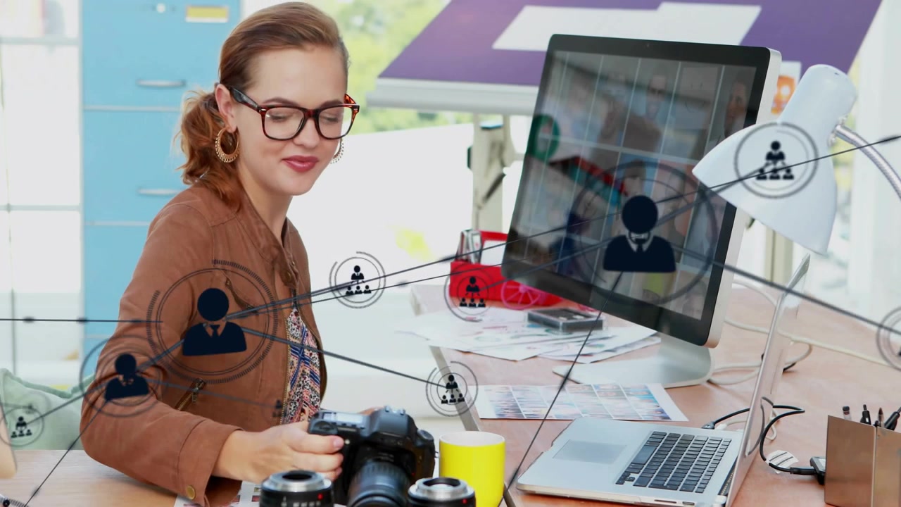 Woman checking DSLR, scrolling laptop while comparing prints for editing as network icons expanding