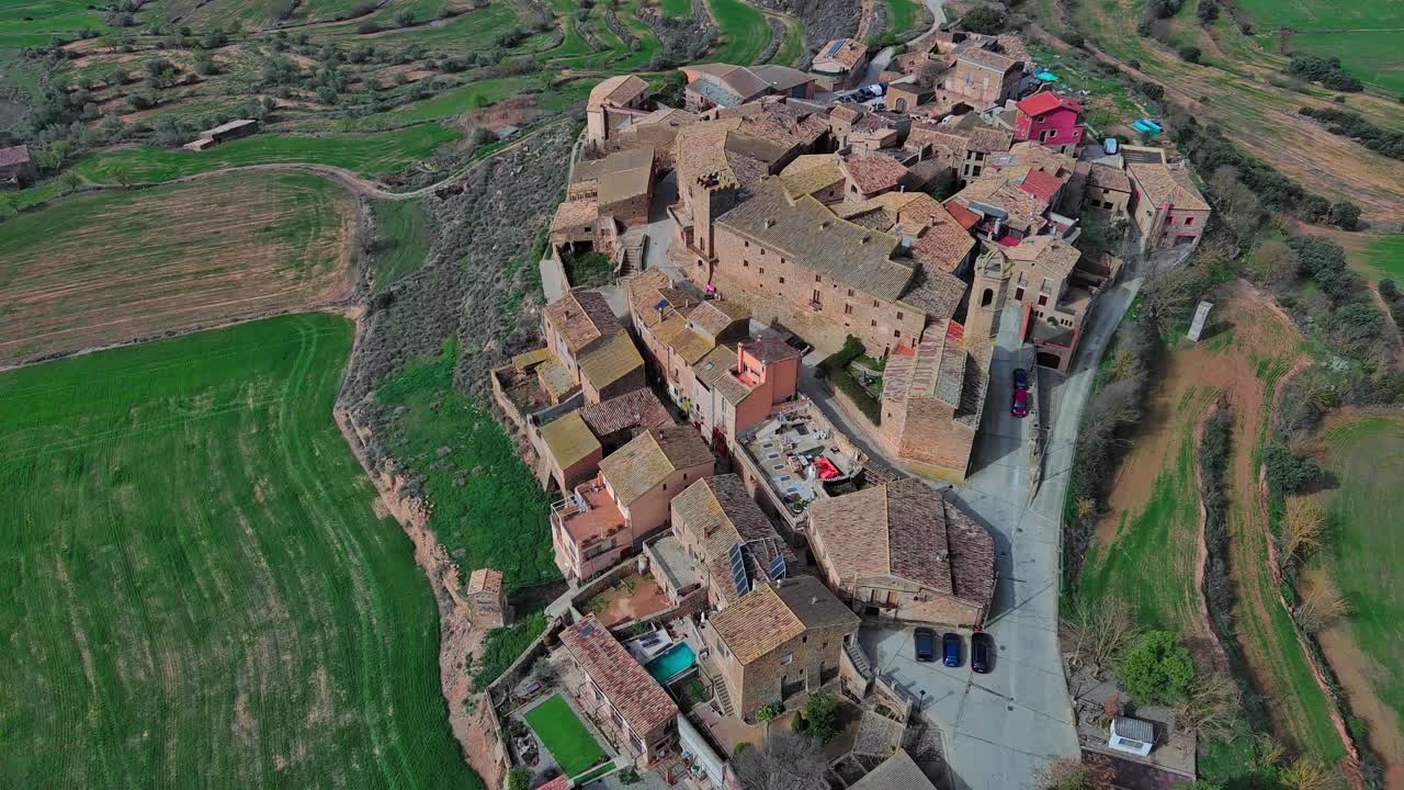 Volo di drone sul villaggio medievale di Florejachs e campi verdi.