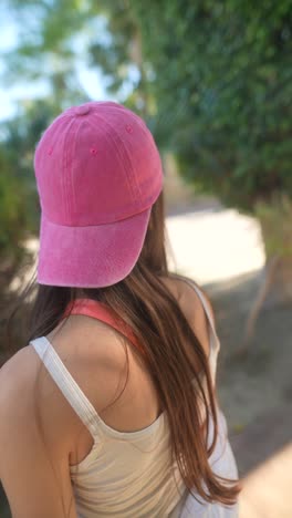 young woman in pink cap and white shirt