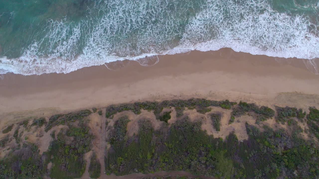 imágenes verticales de drones en movimiento lento de las dunas, la playa y las olas en point lonsdale, victoria, australia