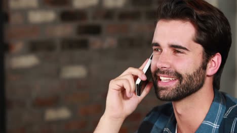hombre hipster sonriente discutiendo por teléfono