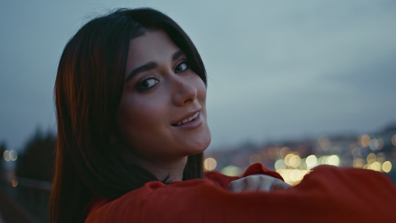 Closeup smiling brunette posing twilight cityscape. Romantic lady looking camera