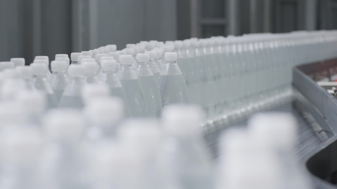 cinta transportadora con botellas de agua potable en una planta de bebidas moderna