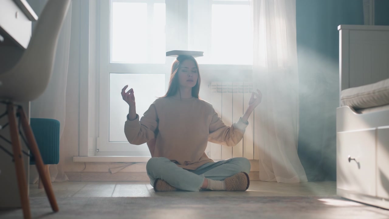 Mulher equilibrando um livro enquanto pratica gramática perto de uma janela luminosa. Ambiente de treinadora doméstica divertido com raios de sol suaves, movimentos leves e exercícios de respiração para melhorar a postura e a confiança ao falar.