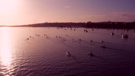 Gente-Remando-En-Kayak-Y-Kayak-Con-Veleros-Flotando-En-Las-Tranquilas-Aguas-En-Un-Hermoso-Amanecer-En-Auckland,-Nueva-Zelanda