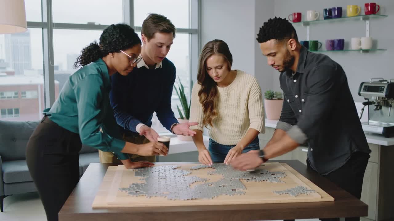 Video verticale: Quattro persone in abiti da lavoro che risolvono un puzzle in salotto, socializzando davanti a caffè e pezzi.