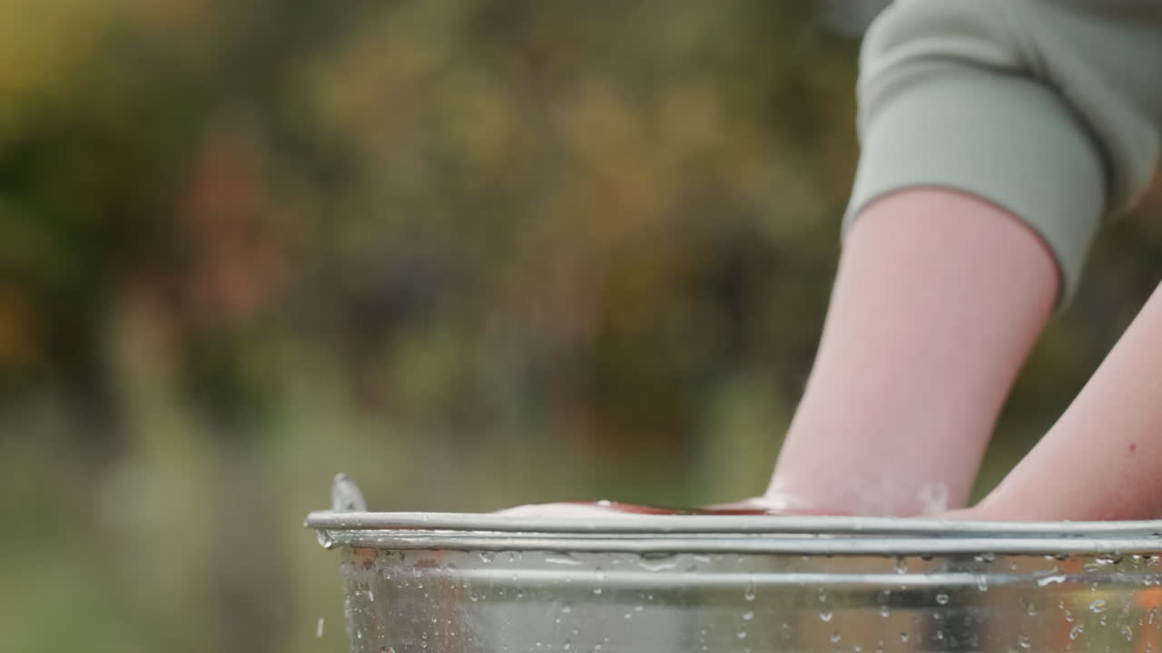 un granjero sostiene manzanas rojas sobre un balde de agua