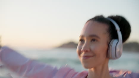 dancing, headphones and young woman at the beach