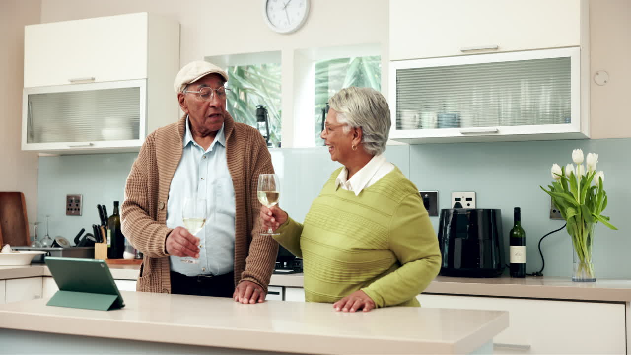 Seniorenpaar stößt mit Wein in seiner Küche an