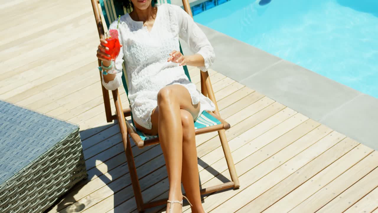 Fron view of young mixed frace woman relaxing on sun lounger in the backyard of home 4k