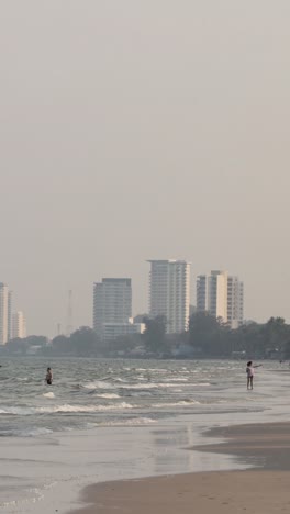 a serene beach with city skyline and moving figures