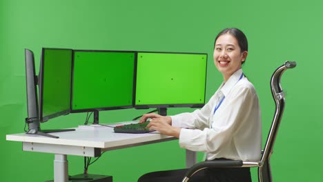 초록색 화면 모니터 를 가진 컴퓨터 에 앉아 있는 여자